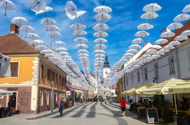 Cakovec, Hırvatistan - 14 Temmuz 2023: Eski Cakovec kentinde beyaz şemsiyelerle gezinti