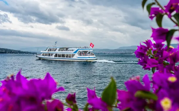 Zürih, İsviçre - 7 Temmuz 2023: Yolcu taşıyan bir turizm gemisi Zürih Gölü üzerindeki Zürih durağından ayrılıyor