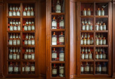 Beaune, Fransa - 16 Ağustos 2023: Beaune 'deki tarihi hastanenin eczane ahşap dolabı - ilaç hazırlamak için gerekli malzemeler. Eski eczanelerdeki raflarda şişeler. Klasik tıbbi geçmiş.