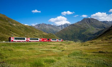 Oberalppass, Switzerland - August 21, 2023: The Glacier Express, a tourist panoramic train that crosses swiss Alps. clipart