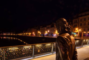 Besancon, Fransa - 7 Ağustos 2023 Pont Battant 'taki Jouffroy d' Abbans heykeli Quai Vauban, Doubs Nehri ve Chaudanne Tepesi 'ni izliyor. Mavi saat fotoğrafı.