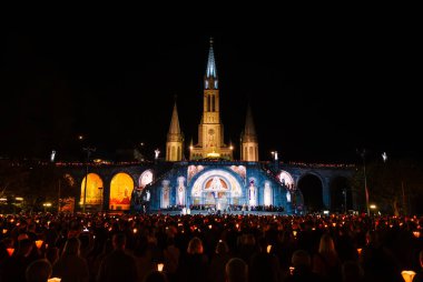 Lourdes, Fransa - 10 Ekim 2023: Aydınlatılmış Lourdes Kilisesi, Bakire Meryem 'in hayaletlerinin yeri,