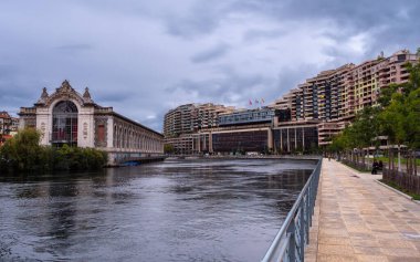 Cenevre, İsviçre - 3 Haziran 2022: Konut binaları ve Cenevre 'de Usine des Forces Motrices adlı eski bir hidroelektrik santrali ve Rhone Nehri üzerindeki su tesislerinin elektrik santrali.