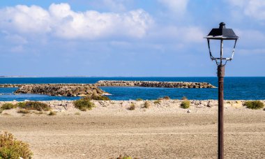 Saintes Maries de la Mer, Camargue, Fransa 'da Akdeniz kıyısındaki boş bir sahilde eski bir fener.
