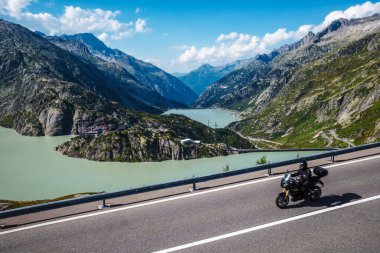 Grimselsee reservoir on the Grimsel mountain pass in Switzerland - a popular destination for bikers clipart