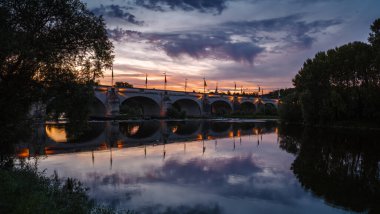 Tours 'daki Loire Nehri' nin yanında gün batımı ve Tours 'un en eski köprüsü olan Wilson Köprüsü' nün manzarası.
