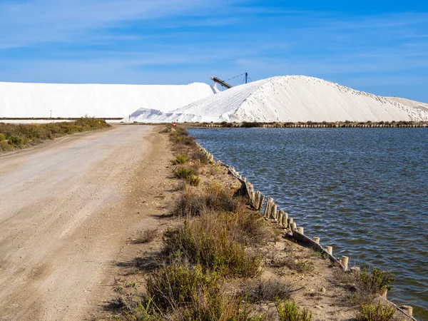 The newly produced salt from the salt pans in Aigues Mortes, France, is transported on a conveyor belt on the top of a salt pile, a so-called camel or pyramid - wide shot, steadicam