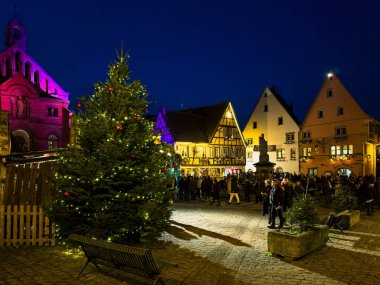 Eguisheim, Fransa - 23 Aralık 2023: Şarap yolu boyunca Alsace 'ın orta çağ kasabası Eguisheim' da geleneksel Noel pazarı - mavi saat