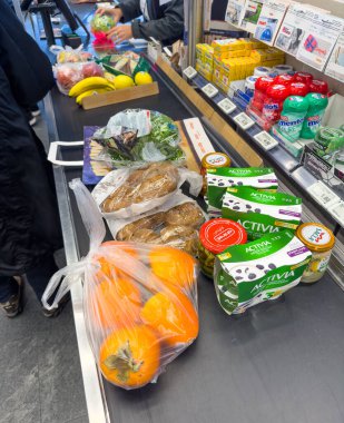 Regensdorf, İsviçre - 4 Aralık 2023: Marketteki kasanın önünde farklı gıda ürünleri var.