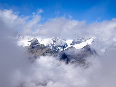 Valais Kantonu 'ndaki Zermatt' ın yukarısındaki Gornergrat 'ın üzerindeki İsviçre dağ manzarasında, Idyllic manzara bulutlara yayılıyor.
