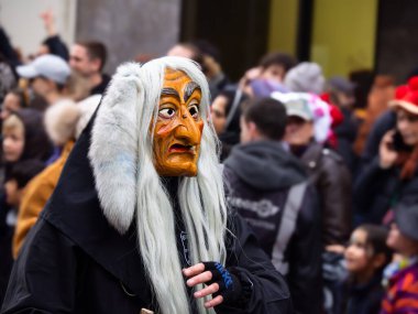 Freiburg, Breeisgau, Almanya - 12 Şubat 2024: Masquerade. Karnaval geçidinde güzel bir maske. İnsanlar arka planda bulanık..
