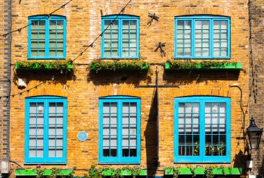 Londra, Birleşik Krallık - 29 Nisan 2024: Mavi pencereli turuncu cephe, Londra 'nın Covent Garden bölgesinde renkli ve canlı bir ara sokak. Monty Python 'un Evi