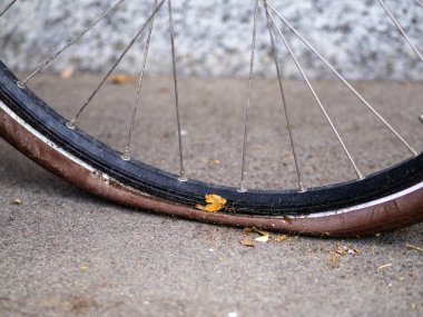 Close-up of a deflated bicycle tire on a concrete surface outdoors. clipart