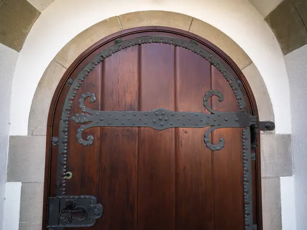 stock image Antique historical wooden arched church door with metal detailing.