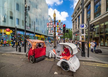 Londra, Birleşik Krallık - 25 Haziran 2024: Londra 'nın canlı kentsel sokak köşesi bisikletçiler, rikşovlar ve mimari simgelerle. Londra 'daki İsviçre mahkemesi