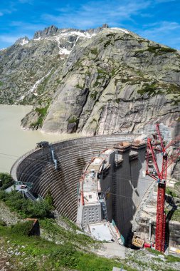 Grimsel, Switzerland - July 5, 2024: Construction work on the artificial lake dam on the Grimselpass clipart