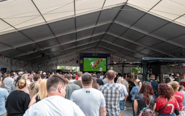 Vaduz, Lihtenştayn - 5 Temmuz 2024: Seyircilerden oluşan bir kalabalık büyük bir açık hava ekranında şampiyonluk maçı izliyor