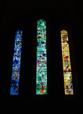 Zurich, Switzerland - July 1, 2024: Three tall stained glass windows from Marc Chagall in Fraumunster reformed church in Zurich, with biblical scenes clipart