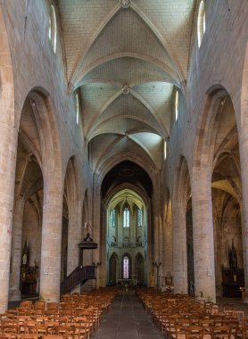 Dinan, Fransa - 19 Temmuz 2024: Dinan 'daki Gotik Aziz Malo Bazilikası, ahşap sandalyeler, taş kemerler, vitray pencereler.