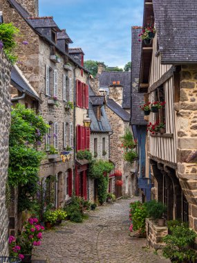 Dinan, Fransa - 19 Temmuz 2024: Dinan 'daki Rue du Jerzual sokağı ortaçağ mimarisi ve canlı sanatsal atmosferiyle tanınan büyüleyici ve pitoresk bir cadde.