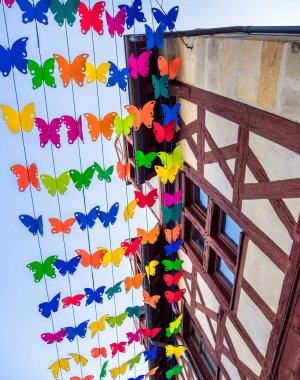 Festive summer outdoor scene in Montlucon, France, with colorful hanging flowers. clipart