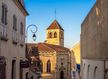 Montlucon, Fransa - 18 Temmuz 2024: Montlucon 'da tarihi kilise, klasik lamba ve sakin bir ortam ile antika cadde.