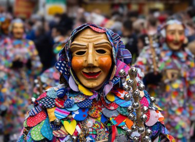 Maskeli balo. Arka planda bulanık insanların olduğu bir karnaval geçidinde yüzü pozitifleşen güzel maske..