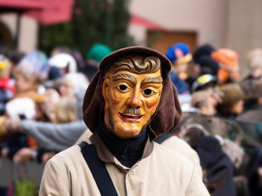 Maskeli balo. Arka planda bulanık insanların olduğu bir karnaval geçidinde güzel bir maske..