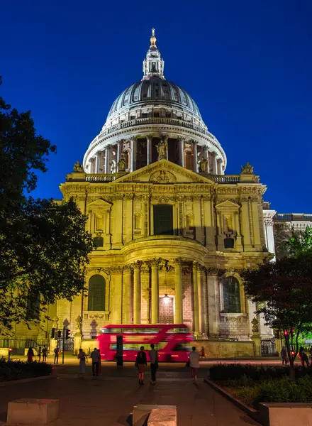 Londra, Birleşik Krallık - 25 Haziran 2024: Aydınlatılmış bir St. Pauls Katedrali önünden geçen kırmızı çift katlı otobüs.