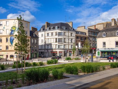 Saint-Brieuc, Fransa - 21 Temmuz 2024: Saint-Brieuc 'da yeşil, modern binalar ve bir binanın yan tarafında bir duvar resmi bulunan canlı bir kent manzarası.