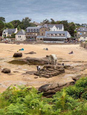 Ploumanach, France - July 23, 2024: Beach View of Perros-Guirec with Rocky Formations and Buildings clipart