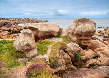 Pembe granit taşların kayalık oluşumlarını içeren manzaralı bir kıyı manzarası. Ploumanach, Brittany, Pembe granit sahili