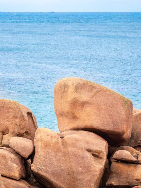 Pembe granit taşların kayalık oluşumlarını içeren manzaralı bir kıyı manzarası. Ploumanach, Brittany, Pembe granit sahili