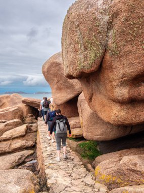 Ploumanach, Fransa - 23 Temmuz 2024: Pembe granit taşların kayalık oluşumlarının yer aldığı manzaralı bir kıyı manzarası. Ploumanach, Brittany, Pembe granit sahili