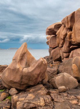 Pembe granit taşların kayalık oluşumlarını içeren manzaralı bir kıyı manzarası. Ploumanach, Brittany, Pembe granit sahili