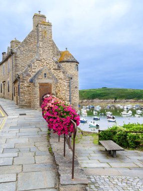 Coastal breton house in the village of Conquet with a harbor. Moored boats. clipart