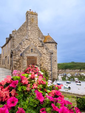 Limanı ile birlikte Conquet köyündeki kıyı Breton evi. Bağlı tekneler ve canlı çiçek düzenlemeleri..