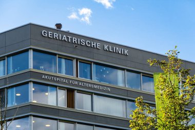Sankt Gallen, İsviçre-27 Eylül 2024: Çağdaş yaşlılık kliniği binası. Temiz hatlar, geniş pencereler ve profesyonel bir atmosfer çok açık. Bina hasta bakımına odaklandığını gösteriyor..
