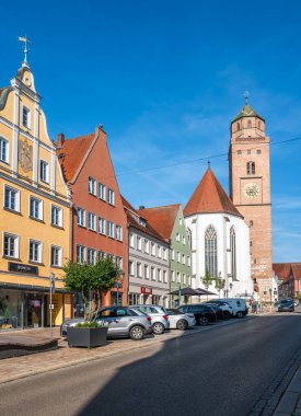 Donauworth, Germany - August 7, 2024: A picturesque street in Donauworth with colorful buildings and a historic church tower under a clear blue sky. clipart