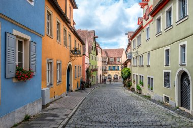 Rothenburg ob der Tauber, Almanya - 8 Ağustos 2024: Rothenburg ob der Tauber 'in Urban Caddesi, pitoresk caddeleri, yarı ahşap evleri ve tarihi işaretleri olan iyi korunmuş bir ortaçağ kasabası.