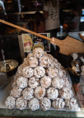 Rothenburg ob der Tauber, Almanya - 8 Ağustos 2024: Bir fırın penceresinde piramit şeklinde dizilmiş geleneksel Alman kurabiyeleri, Schneeballen - kar topları.