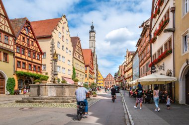Rothenburg ob der Tauber, Almanya - 8 Ağustos 2024: Rothenburg ob der Tauber kentsel yaşamı, pitoresk caddeleri, yarı ahşap evleri ve tarihi eserleri olan iyi korunmuş bir ortaçağ kasabasıdır.
