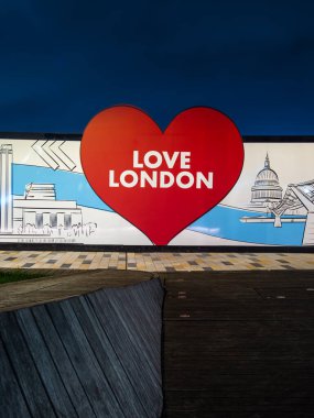 Londra, Birleşik Krallık - 27 Ekim 2024: Sembolik simgelerin ortasındaki kırmızı bir kalbin içindeki aşkı gösteren canlı bir duvar resmi.