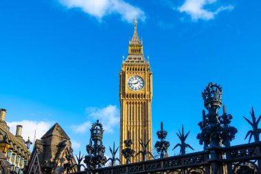Londra 'da Big Ben olarak bilinen ikonik saat kulesi açık mavi gökyüzüne karşı