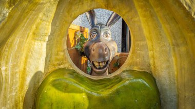 Londra, Birleşik Krallık - 24 Kasım 2024: Eşek heykeli büyük, sarı bir yapıda dairesel bir açıklıktan bakar. Neşeli ifade, neşeli ve esprili sahne.