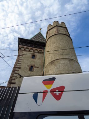 Basel, İsviçre - 17 Ağustos 2024: Tarihi Spalentor kulesi kapısı, Fransa, Almanya ve İsviçre 'nin bayraklarının yer aldığı bir logo sergileniyor - Basel üç sınırlı bir şehir