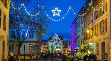 Colmar, Fransa - 28 Kasım 2024: Colmar, Alsace, Fransa 'da renkli dekorasyonlar, ışıklandırma ve aydınlatma ile Noel pazarı.