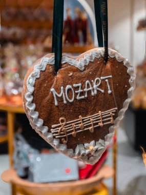 Salzburg, Avusturya - 24 Ekim 2024: Mozart isimli dekoratif zencefilli kek kalbi ve kremayla yazılmış notalar. Bir kurdeleye asılı..