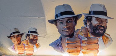 Innsbruck, Avusturya - 20 Mart 2025: Bud Spencer ve Terence Hill - iki ünlü film figürü. Duvarda iki boyutta panoramik tasvir