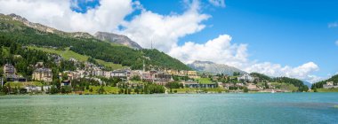 St.Moritz, İsviçre - 8 Temmuz 2024: Dağları, renkli binaları ve yemyeşil yeşillikleri olan sakin göl kenti Sankt Moritz manzarası.